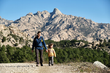 Fototapeta premium Family hiking in the mountains. A mother and her son take a hike together in the mountains