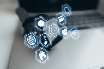 The concept of different settings and applications for smart watches. Holography with icons over clock and laptop.