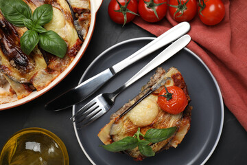 Plate of delicious eggplant lasagna served on black table, flat lay