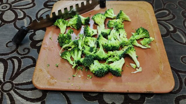 Broccoli finely chopped on aplastic vegetable cutter for stir fry
