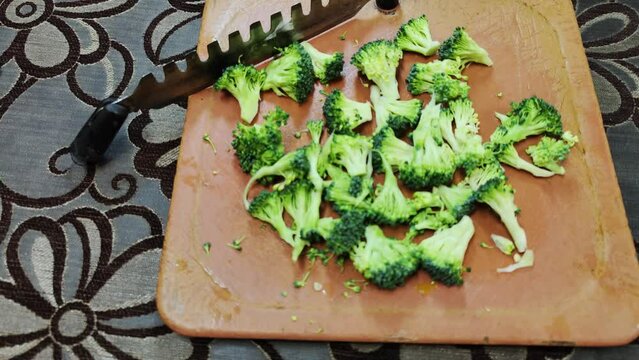 Broccoli finely chopped on aplastic vegetable cutter for stir fry
