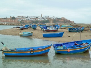 Fototapeta na wymiar Colorful fishing boats on Bou Regreg river, charming Sale, neighboring city to Rabat, in the background. Morocco.