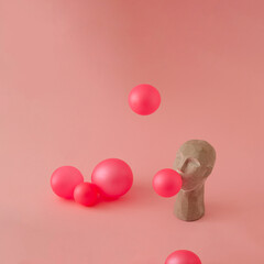 An interesting and dynamic concept on a pastel pink background. A gray sculpture of Asians blowing pink bubblegum balloons scattered all around..  Concept art