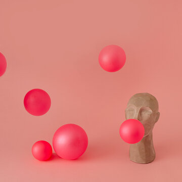  A sculpture of an Asian making balloons out of chewing gum. Balloons are scattered all around on a pastel pink background .  Concept art