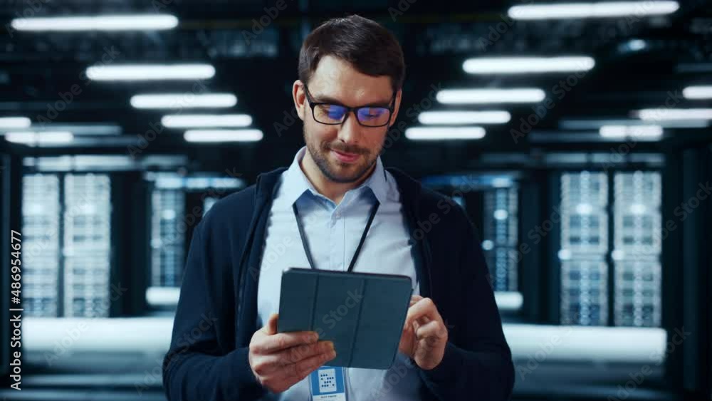 Fototapete portrait of a bearded handsome caucasian it specialist in glasses standing with tablet and posing in