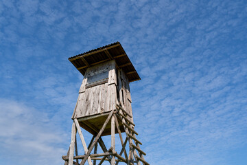 Wooden hunting tower in the blue sky 