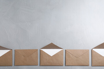Many brown paper envelopes on light grey table, flat lay. Space for text