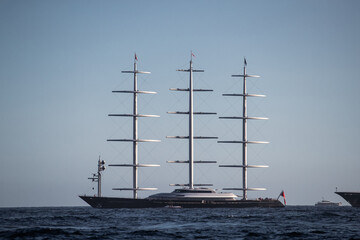 A huge sail yacht of conceptual design with three masts stands in the bay near Monaco at sunny day,...