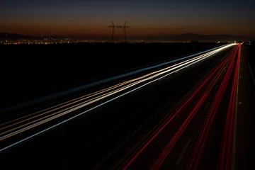 Fotobehang Cars light trails on a straight highway at sunset. Night traffic trails, Motion blur, Night city road with traffic headlight motion. © Bojan