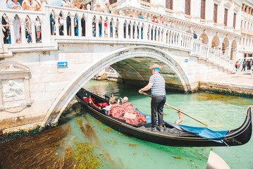 Italy, Venice - May 25, 2019: people at gondola taking tour by canal