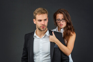sexy formal couple in love in business look on black background, business