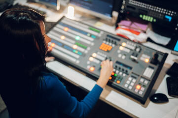 Middle aged woman using equipment in control room on a tv station