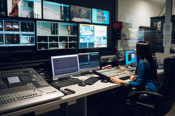 Middle aged woman using equipment in control room on a tv station