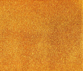 Gold glitter texture. Shiny background for postcards and greeting design. Festive rich backdrop. Sparkling sequins.