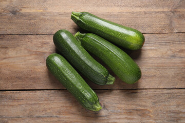 Raw ripe zucchinis on wooden table, flat lay