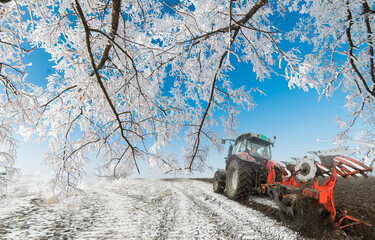 Tractor plowing a field in winter