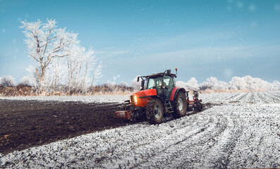 Tractor plowing a field in winter
