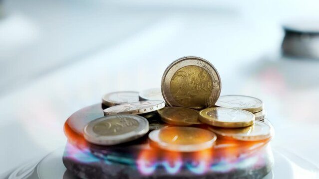 Concept of gas crisis. 2 Euro coins is burning on a kitchen stove burner and fall when the gas end. High prices of natural resources. Fire flame. Utility debt. Energy war. Saving home budget. Finance.
