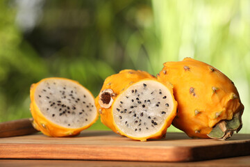 Delicious cut and whole dragon fruits (pitahaya) on wooden table