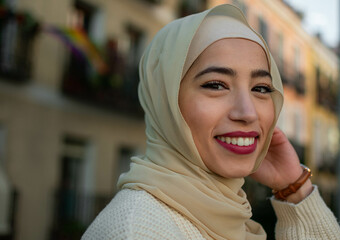 Pretty young muslim woman in hijab scrolling outdoors 