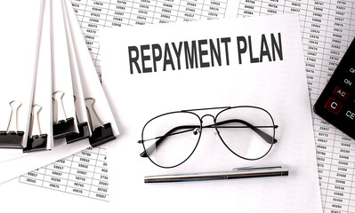 REPAYMENT PLAN text on paper with chart and office tools , business concept