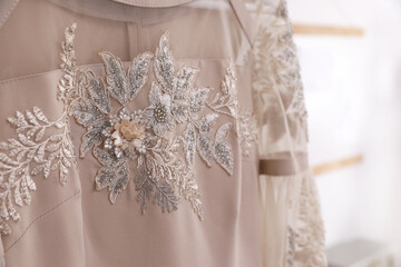 Beautiful beige dress with floral embroidery, closeup