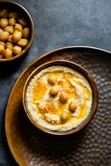Close up of hummus dip with chickpeas and oil in a bowl