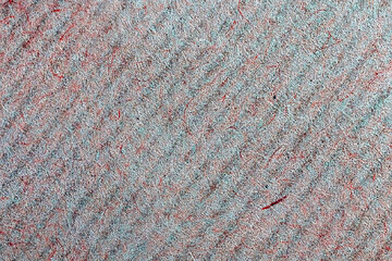 A sheet of red and green paper close-up, macro paper fibers, background with diagonal stripes