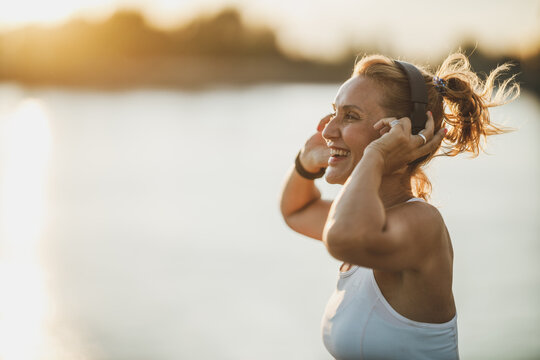 Woman Listening Music And Preparing To Training Near The River
