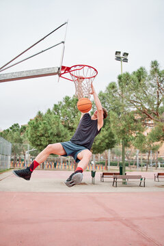 Close Up Of Young Basketball Street Player Making Slam Dunk