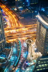 Fototapeta na wymiar Aerial View Of Urban Background Of Illuminated Cityscape With Towers In Dubai. Street Night Traffic In Dudai Skyline. Moving Through Modern City Street With Illuminated. UAE. Vertical High quality