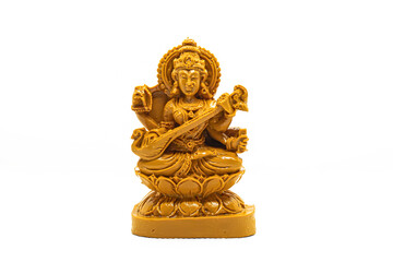 The statue of Saraswati carved in brown wood is isolated in white
