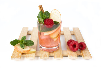 Apple and red fruit iced tea cocktail. Cold drink decorated with apple slices, raspberry, mint leaves and cinnamon. Hydration for the summer.
