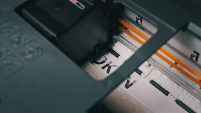 NFT token printing. Process of printing a paper document on a jet printer. Multi-colored inscription NFT token on a white sheet of paper is printed by a printer. Concept of creating non-fungible token
