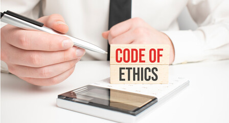 Businessman holding sheet of paper with a message Code of Ethics
