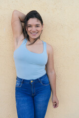 Latin Woman standing outdoors, arms raised and showing armpit hair.