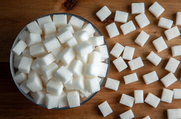 Top view of white sugar cubes in glass bowl,wooden background