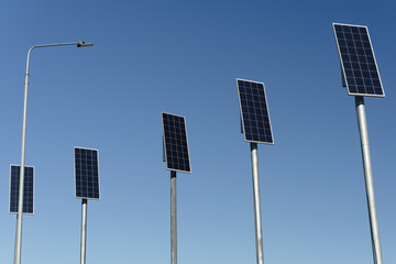 many small solar panels against background of clear blue sky