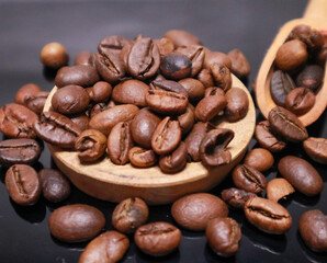 scoop of coffee beans in dark background