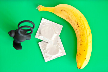 condom with banana and cock ring on green background