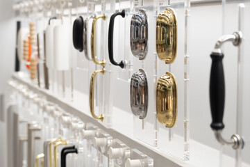 Various furniture fittings are presented on the window in the store. Different colors and shapes