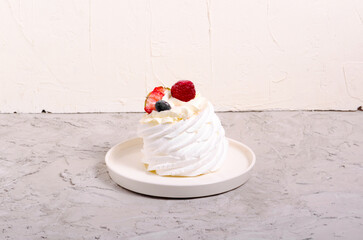 dessert anna pavlova with berries on a gray background