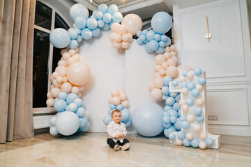 little boy in front of photo zone with balloons