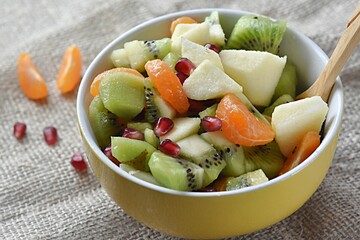 fruit salad of tangerines kiwi apples pomegranate seeds. healthy eating