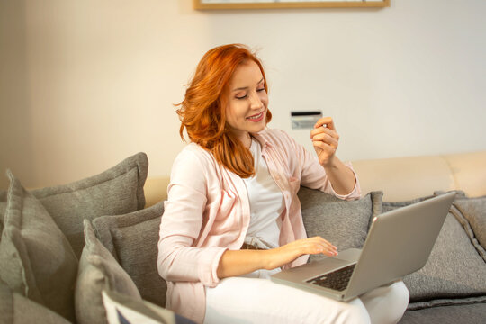 Beautiful Ginger Woman With Laptop And Credit Card At Home.