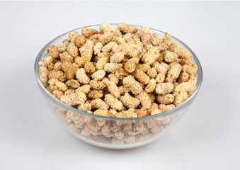 Dried mulberry in glass bowl on white background