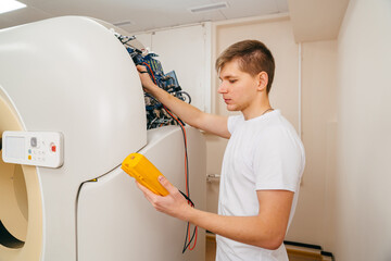 the engineer measures the voltage in the electrical appliance.