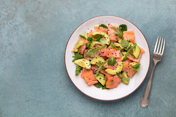 Fresh salmon salad with avocado,  for keto and low carb diet. Rusty background, top view, copy space.
