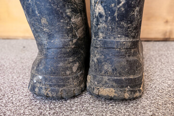 Muddy dirty rubber boots after working on construction and building