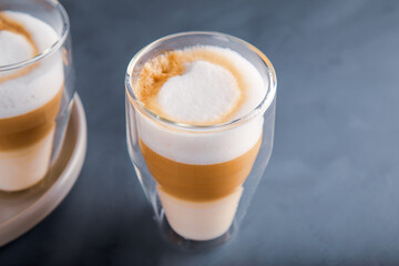 Perfectly gradient latte macchiato view over grey backdrop with copy space.